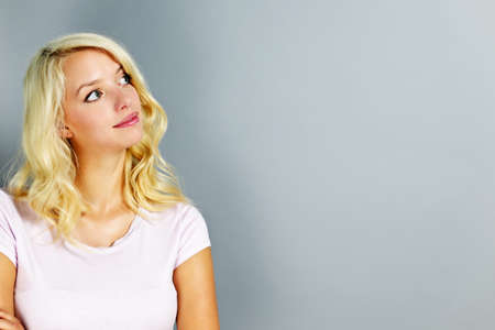 Portrait of young blonde caucasian woman looking to the side and upの写真素材