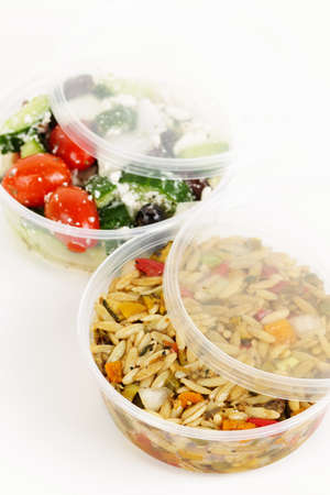 Two servings of prepared salad in plastic takeaway containersの写真素材
