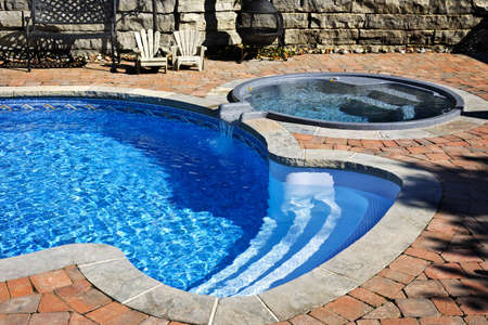 Outdoor inground residential swimming pool in backyard with hot tubの写真素材