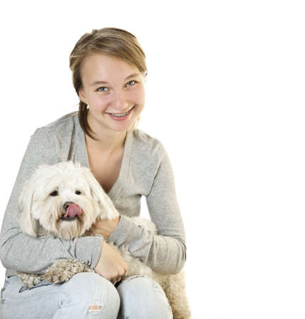 Pretty teenage girl holding adorable coton de tulear dogの写真素材