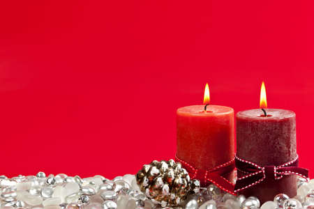 Christmas candles and decorations on red backgroundの写真素材