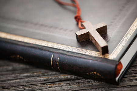 Closeup of simple wooden Christian cross necklace on holy Bibleの写真素材