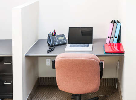 Workstation in office with swivel chair desk and laptop computerの写真素材