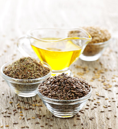 Bowls of whole and ground flax seed with linseed oil