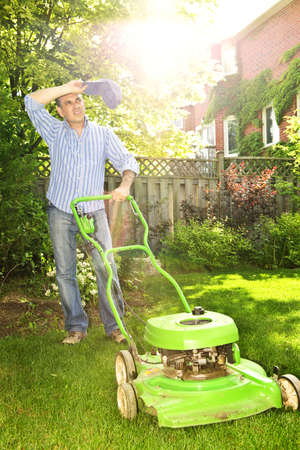 Man taking a break while mowing lawn on hot summer dayの写真素材