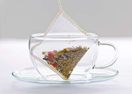 Glass teacup with soothing herbal tea in silk bagの写真素材