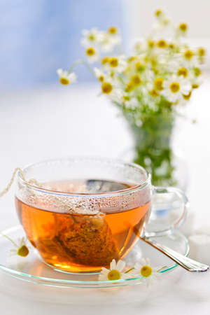 Glass teacup with soothing herbal tea in silk bagの写真素材