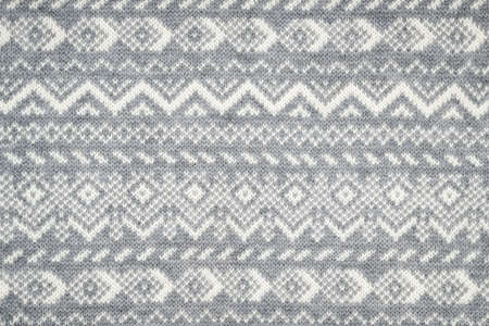 Knit fabric background with knitted grey and white geometric patternの写真素材