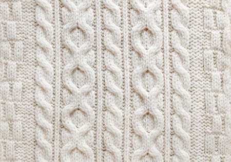 Knit texture of light natural wool knitted fabric with cable pattern as backgroundの写真素材