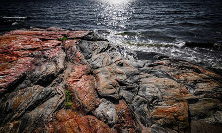 Exposed bedrock and colorful rock formations at rugged Georgian Bay lake shore near Parry Sound, Ontario, Canada.の写真素材