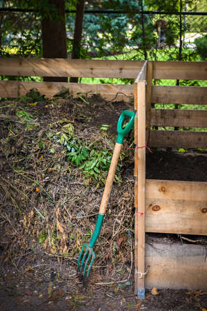 Wooden compost boxes with composted soil and yard waste for backyard garden compostingの写真素材