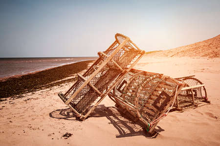 Three lobster traps on Atlantic ocean beach in Prince Edward Island, Canadaの写真素材