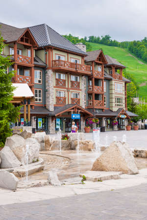 COLLINGWOOD, ON, CANADA - JUNE 18: View of Blue Mountain Village with fountain and shops in summer,...