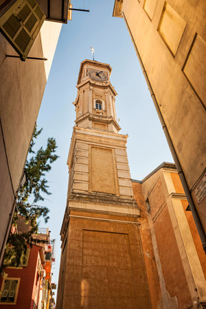 View of the clock tower of Saint Francois in Nice, France, from narrow street in old Nice.の写真素材