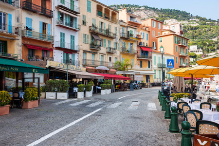 VILLEFRANCHE-SUR-MER, FRANCE - OCTOBER 4, 2014: Restaurants with outdoor patios facing Mediterranean sea welcome tourists on town's colorful waterfront.のeditorial素材