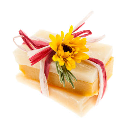 Several herbal handmade artisan soap pieces tied with fresh flowers isolated on white backgroundの写真素材