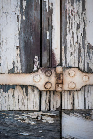 Detail of old wooden window shutters with rusty iron hinge and peeling paint. Toulouse, France.の写真素材