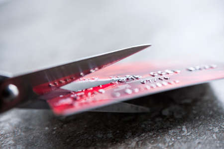 Credit card being cut with scissors, close up with copy spaceの写真素材