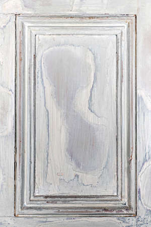 Old distressed wood door panel with peeling paint as framed backgroundの写真素材