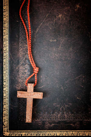Closeup of simple wooden Christian cross necklace on holy Bible with copy spaceの写真素材