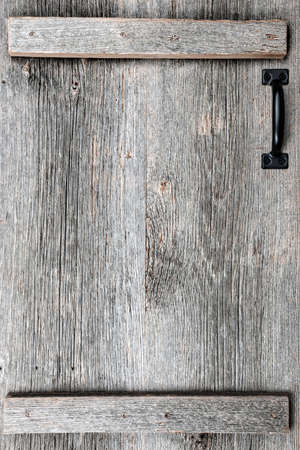 Distressed rustic barn wood door with handle as textured backgroundの写真素材