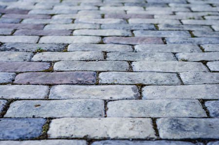 Background of paving stones. Textured gray stones close-up. Old stone road. Soft focus.の写真素材