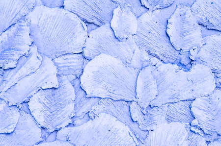 The background is lilac. Abstract drawing made of concrete, made on the wall with special tools. The...