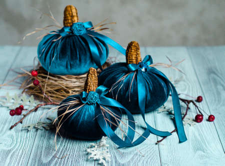 Beautiful blue pumpkins made of velvet fabric are decorated with various elements and ribbons. Home decor for the Halloween holidayの写真素材