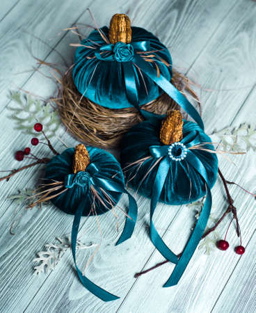 Beautiful blue pumpkins made of velvet fabric are decorated with various elements and ribbons. Home decor for the Halloween holidayの写真素材
