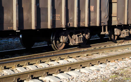 part of moving freight train. Wheels of freight car on rails in motion.の写真素材