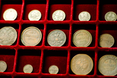 Collection of coins on red velvet background. Money. Old antique coins from time of tsarist Russia.の写真素材