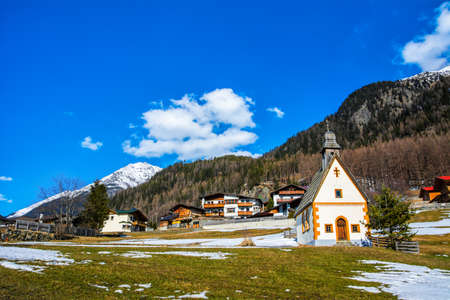 Amazing view of winter wonderland mountain scenery with church in the Alps on a sunny day with blue skyの写真素材