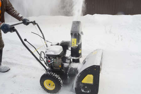 Man cleans snow with snowplow