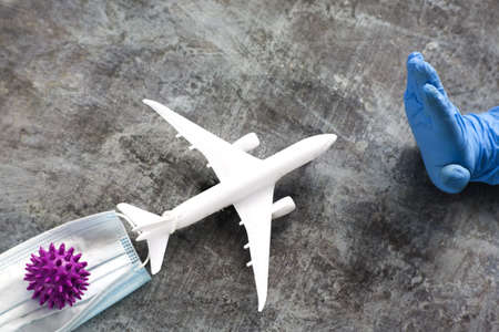 A hand in a blue glove shows a stop to the plane carrying the coronavirus. The ban on air travel for...