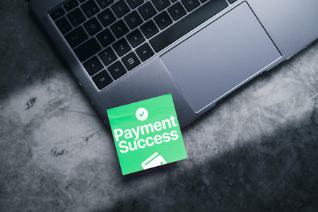 Laptop top view photo with green post-it with payment success written on it. Concept of financial transactions with digital devices. Closeup photo. Money send transfer. Shopping.の写真素材