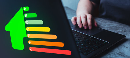 Woman using laptop for house efficiency rating. Concept of ecological and bio energetic house. Energy class.の写真素材