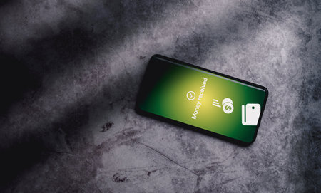 Top view of smartphone with the payment message sent on screen. Concept of financial transactions with mobile devices. Closeup photo. Money sent transfer. Online shopping.の写真素材