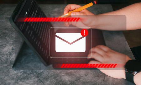 New email spam notification alert with warning caution. Woman receives spam mail on digital tablet. Security protect, junk and trash mail and compromised information.の写真素材