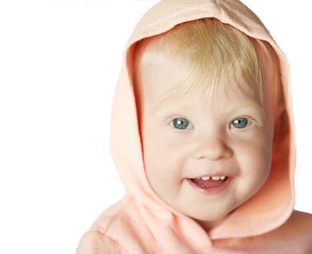 Smiling young blond girl in pink hood (in white).の写真素材