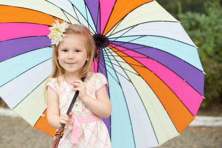 Young girl holding rainbow umbrella.の写真素材