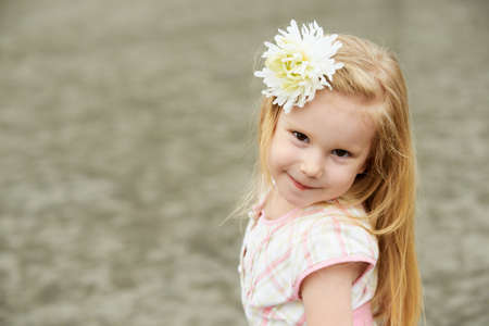 Young girl with flower. Smiling blond.の写真素材
