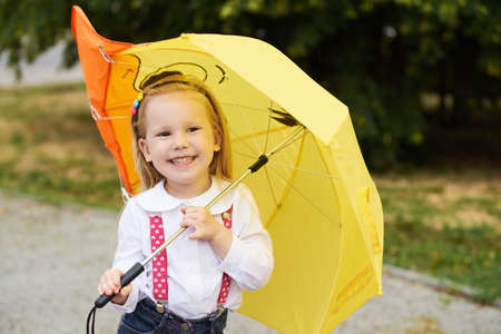 Young girl with yellow umbrella.の写真素材