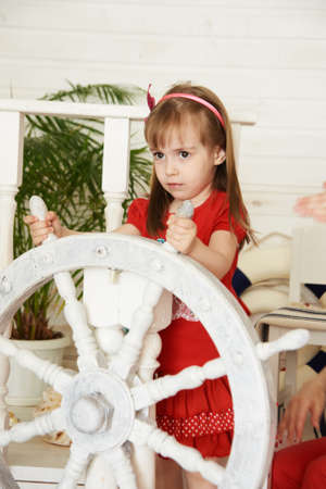 Young girl driving white steering wheel.の写真素材