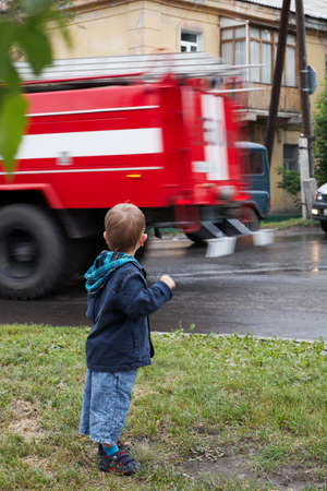 Little boy, red fire truck on roadの写真素材