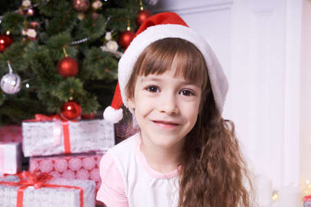 Cute girl. Christmas background. Beautiful giftの写真素材