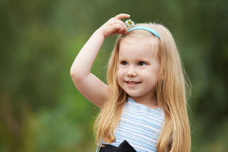 Little girl. Portrait child. Blonde. Chamomile. Green background.の写真素材