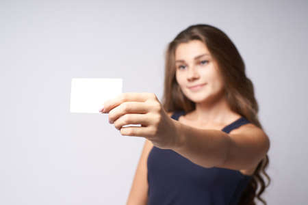 White card. Portrait girl. Blurred background. Arm.の写真素材
