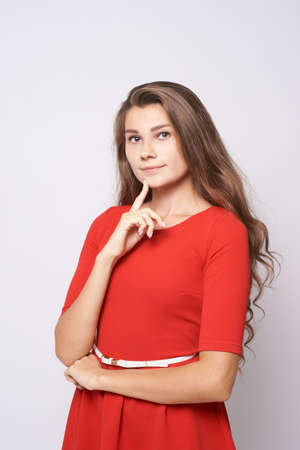 Pensive calm girl. Beautiful portrait. Red dress.の写真素材
