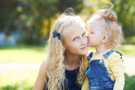 Sisters. Relations. Daughters. Portrait children. Kiss. Love.の写真素材