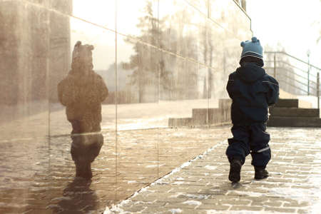 Small child. Stroll. Cold weather. Street.の写真素材